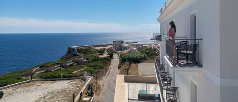 Un edificio frente al mar con un balcón que da a la playa.