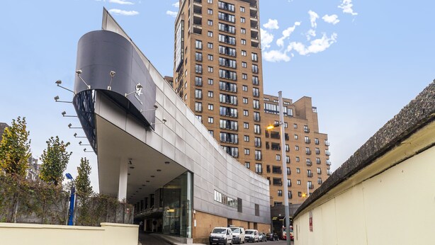 A modern building with a curved facade and a tall adjacent residential building. - Point West Apartments Gloucester Road (London)