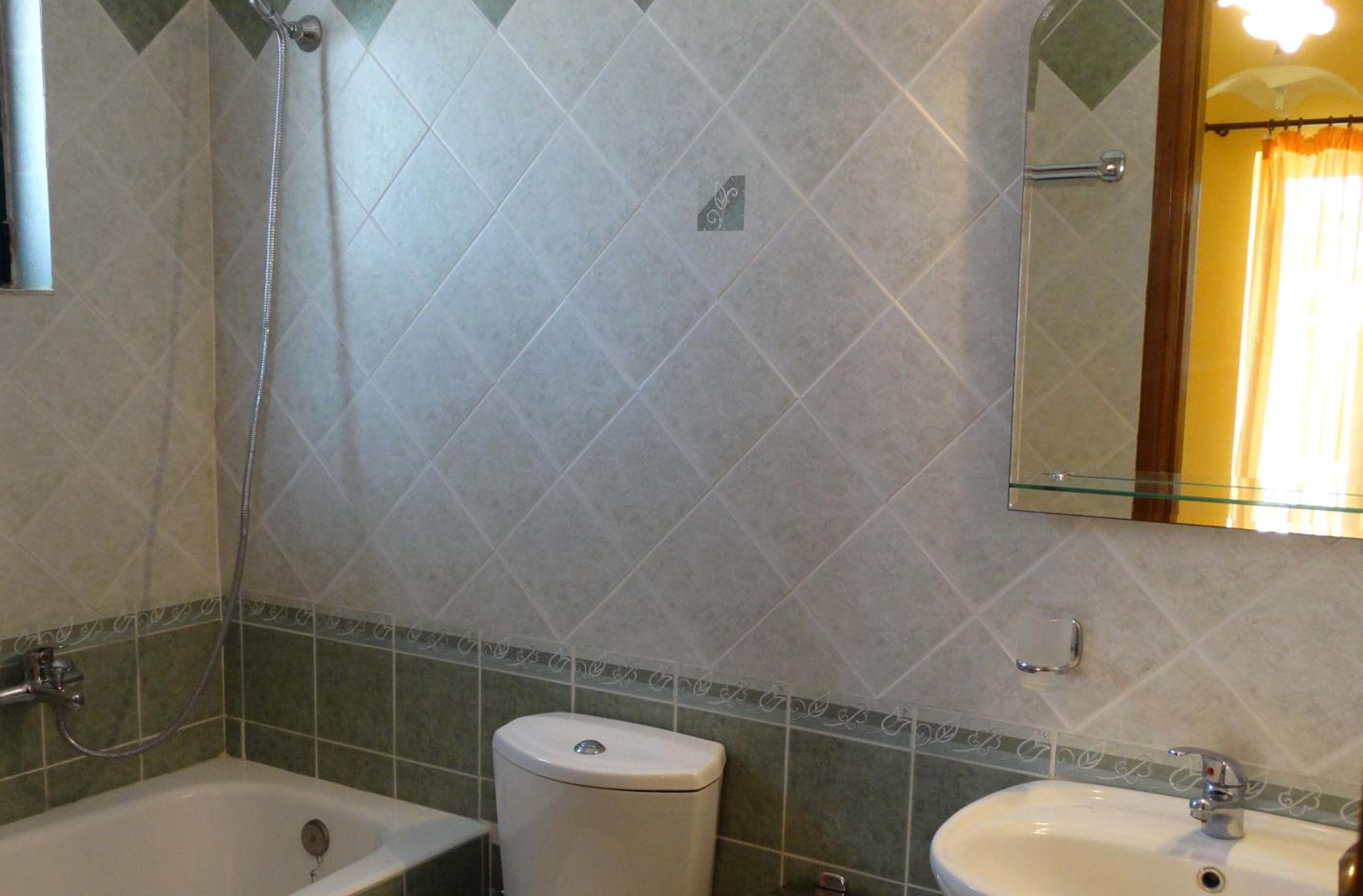 A bathroom with a bathtub, toilet, and sink.