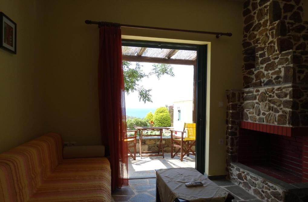A cozy room with a stone fireplace, a sofa, and a table with a remote control.