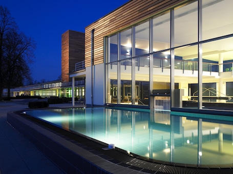 Una piscina techada, sillones reclinables de piscina
