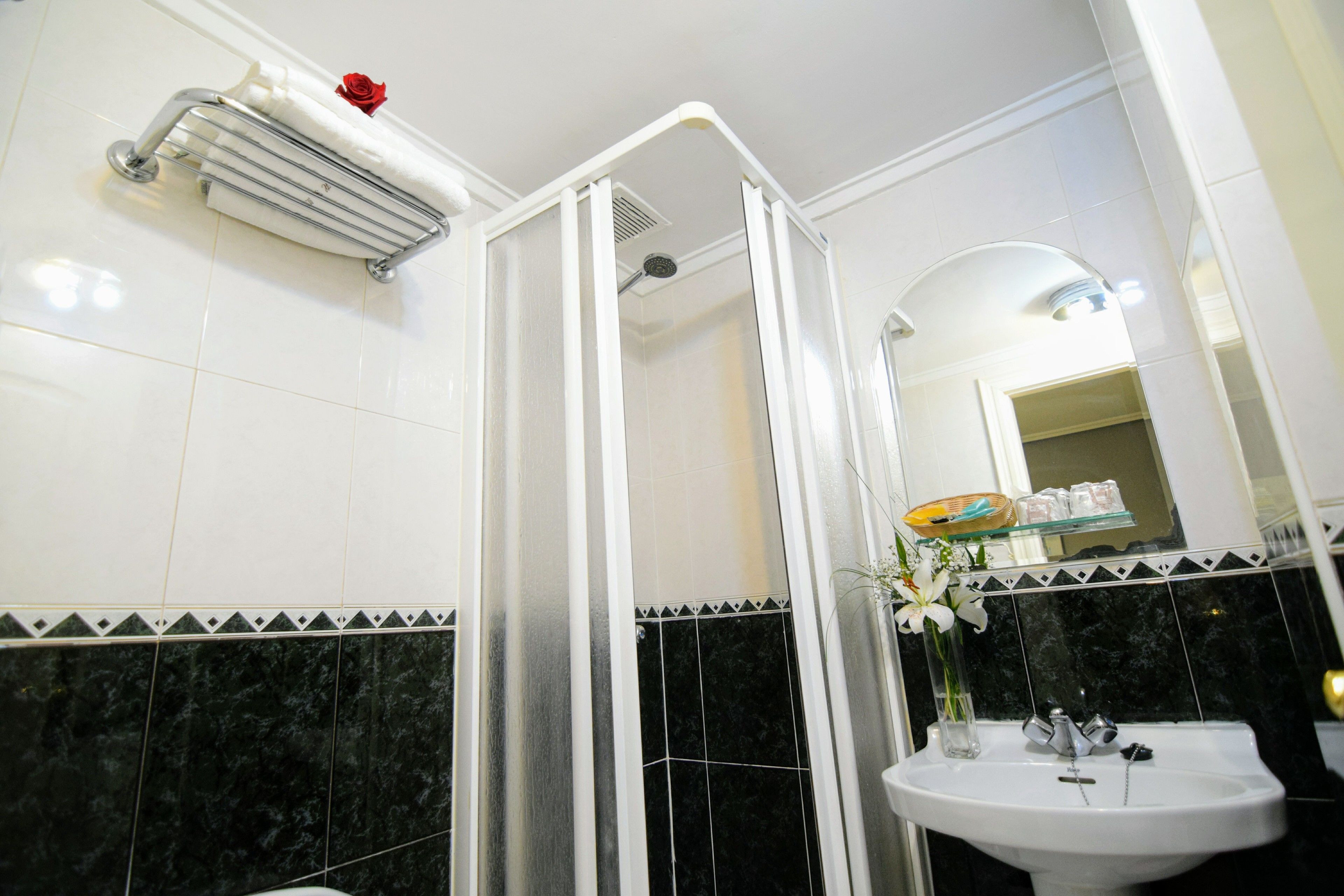 A bathroom with a shower, a sink, and a mirror.