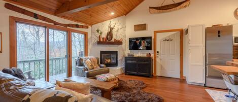 A cozy living room with a fireplace, leather sofa, and a television.
