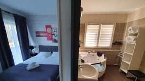 A bedroom with a bed, a bedside table, and a window with curtains. - Les Pelouses (Cucq)