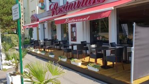 A restaurant with outdoor seating, a red awning, and a sign indicating it is a restaurant. - Les Pelouses (Cucq)