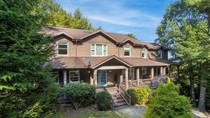 A two-story house with a covered porch and a small front yard. - Luxury Home with In-law Apartment (Boone)