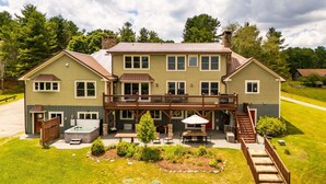 Une maison à deux étages dotée d’une terrasse, d’un jacuzzi et d’un espace salon extérieur.