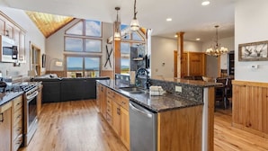 A spacious kitchen with wooden cabinets, a large island, and a view of the outdoors.