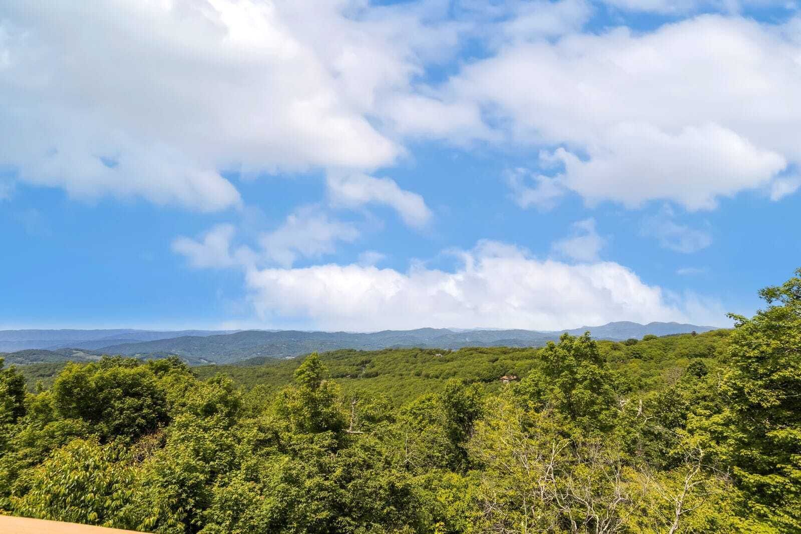 A landscape with a view of distant mountains under a partly cloudy sky.