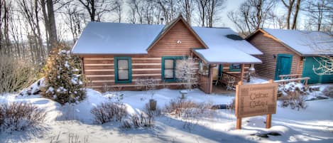 A cabin with a snow-covered roof, a porch, and a sign indicating it is a Celtic Cabin.