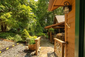 A wooden building with a stone pathway leading to a wooden fence.