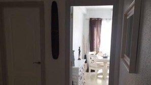 A hallway leading to a dining area with a table and chairs. - Palasiet (Villajoyosa)