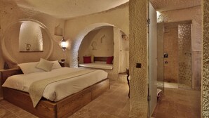 Un dormitorio con una cama de madera, un banco empotrado y un box de ducha de vidrio.