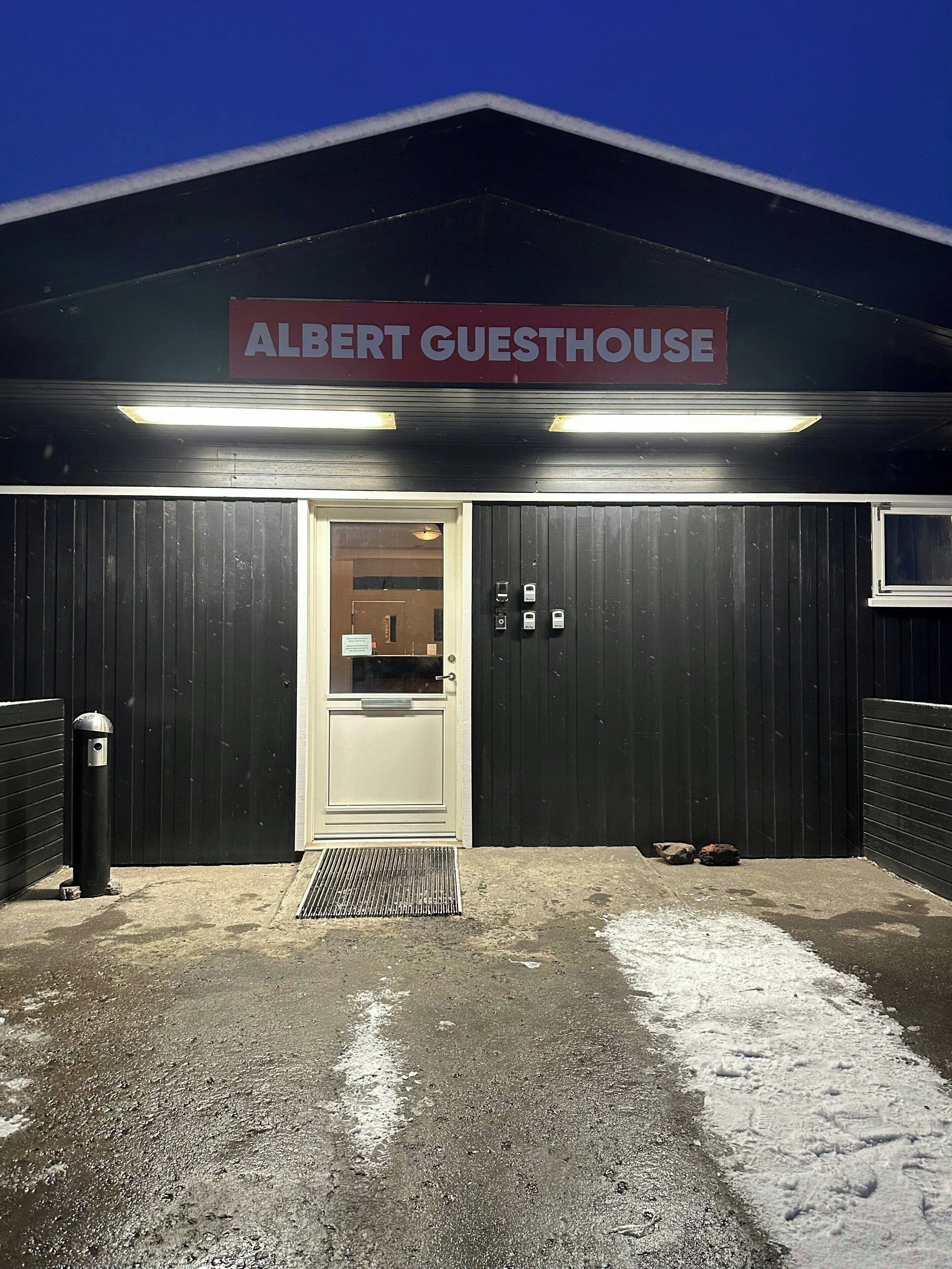 Un bâtiment dont l’entrée est marquée par une enseigne indiquant « ALBERT GUESTHOUSE ».