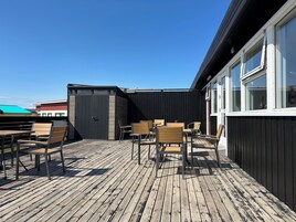 A wooden deck with outdoor seating and a shed.