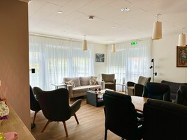 Una sala moderna con un sofá, sillas, una mesa de centro y una mesa de comedor.