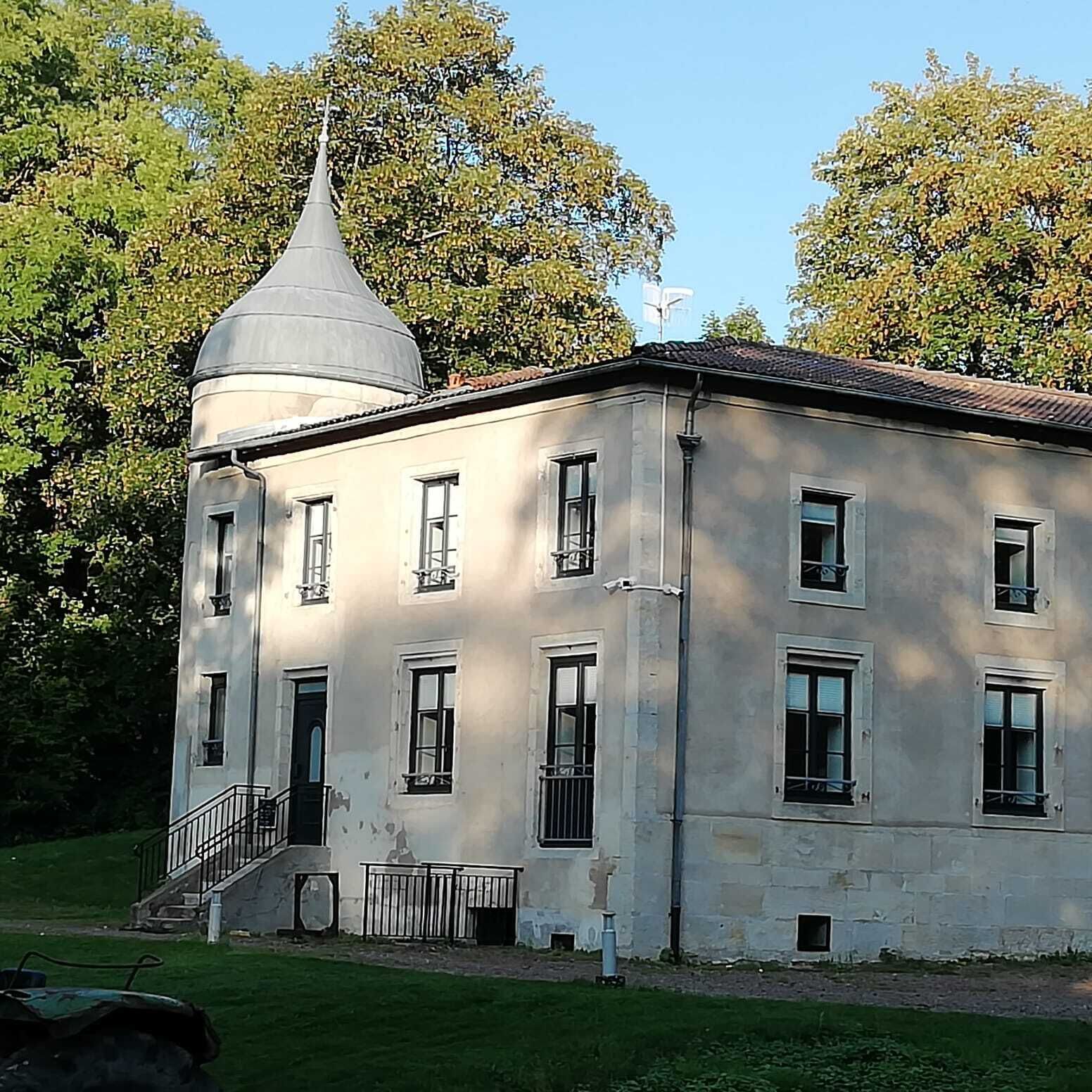 Un edificio a due piani con una cupola centrale e una scala che conduce all'ingresso.