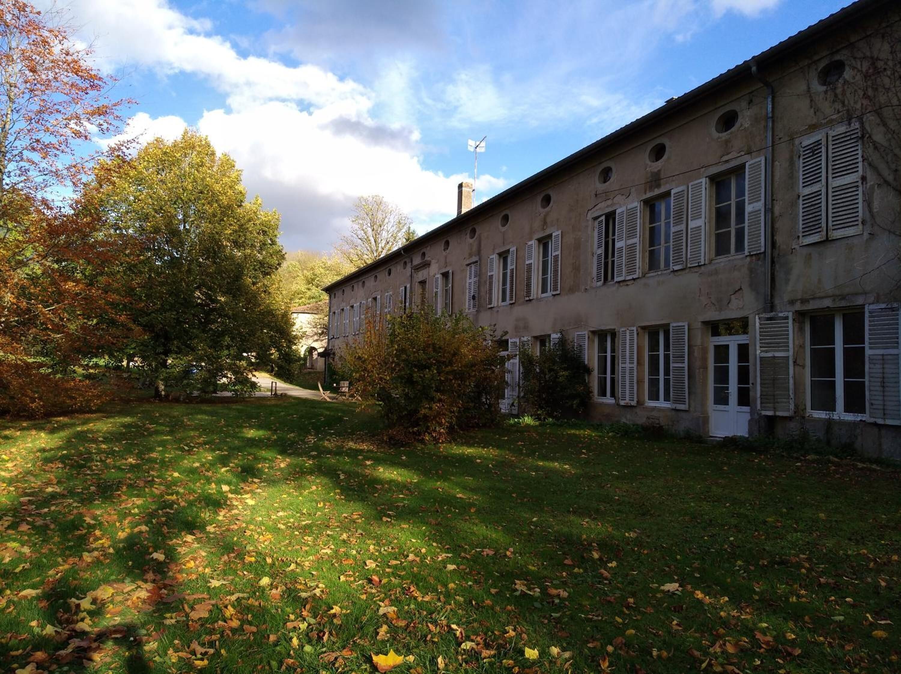 A building with multiple windows and a grassy courtyard.