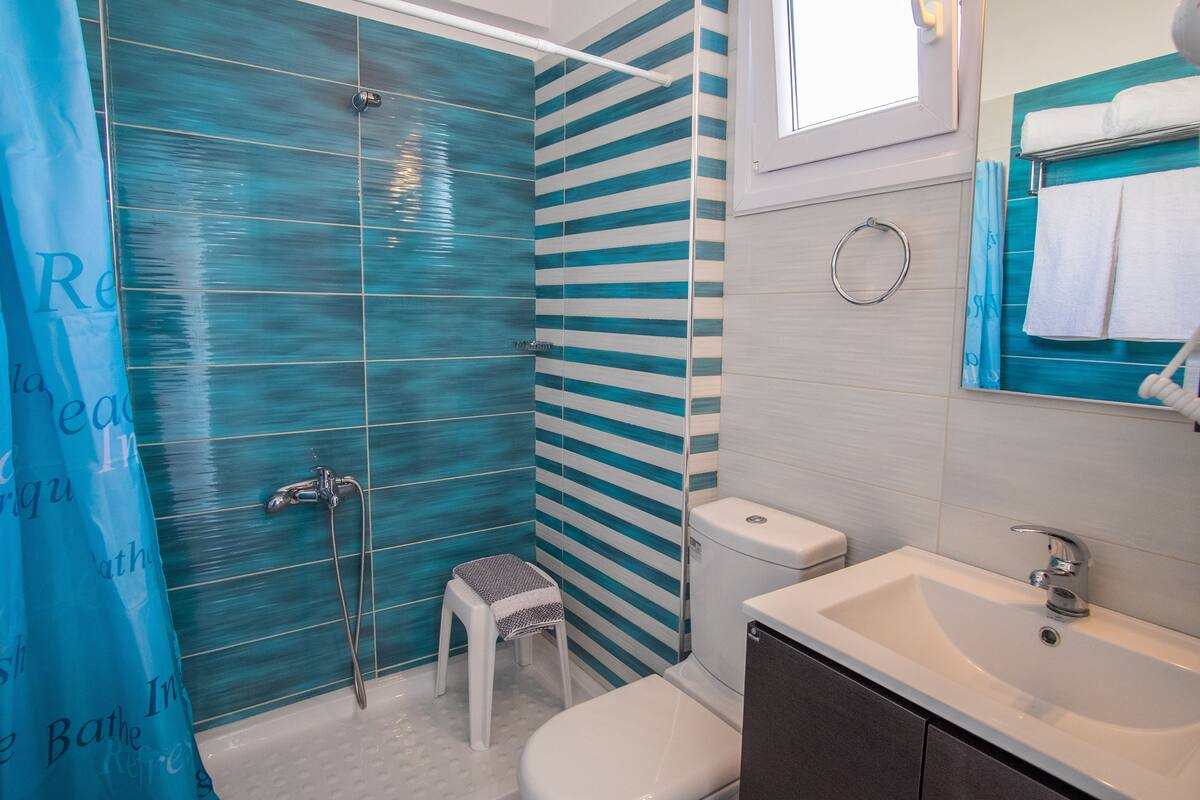deluxe double or twin room, partial sea view | bathroom | shower, free toiletries, hair dryer, slippers