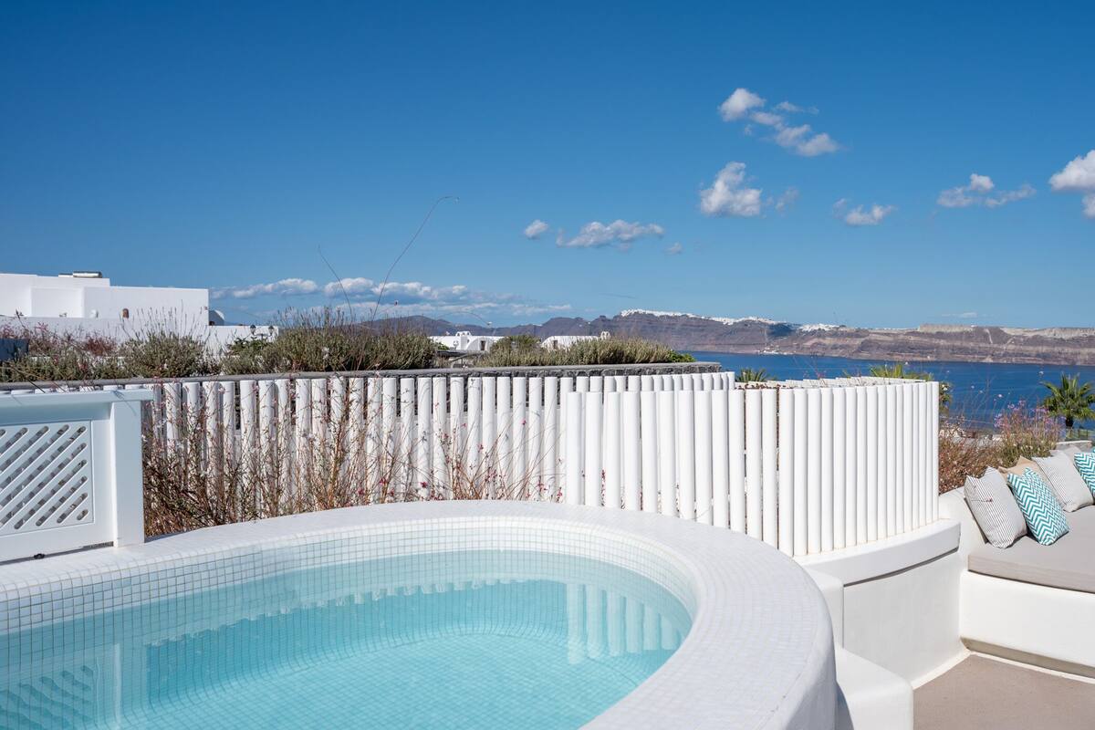 A pool area with a view of the sea and mountains.