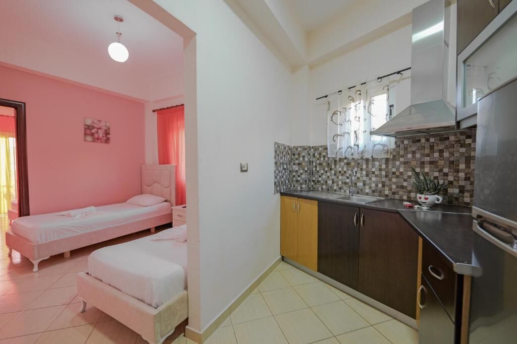 A compact room with a bed, a kitchenette, and a bathroom.