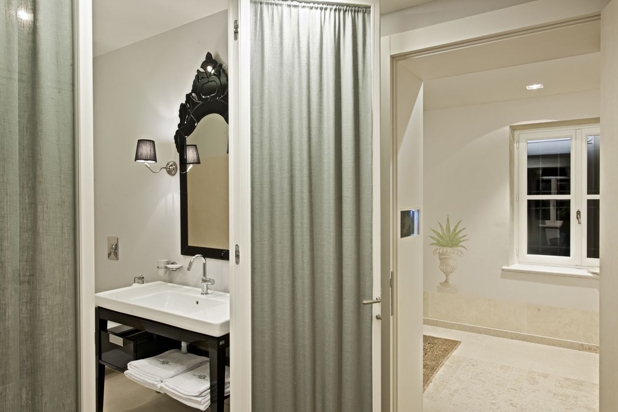 Une salle de bain avec un lavabo blanc, un miroir et un porte-serviettes.
