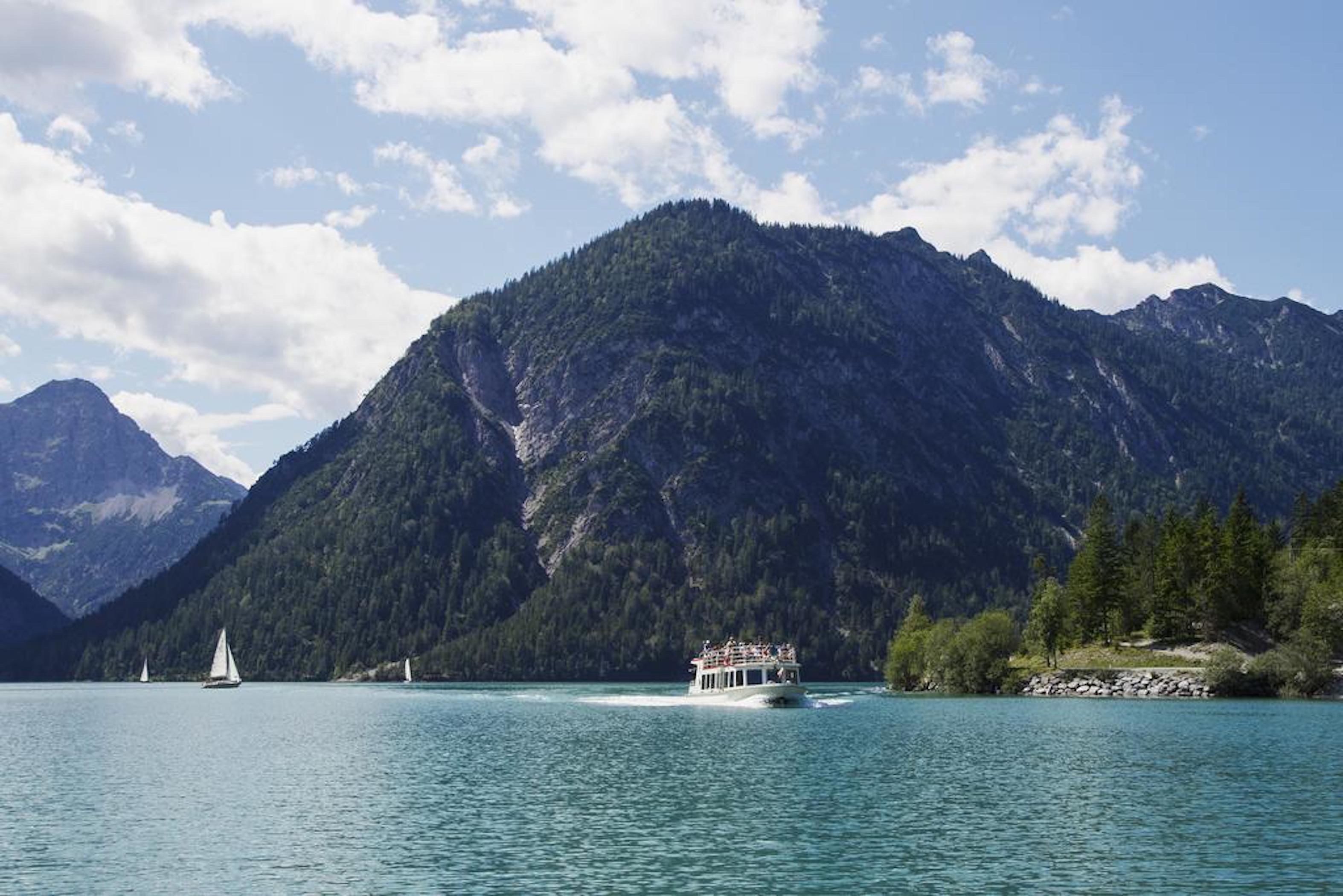 A boat on a lake with mountains in the background.