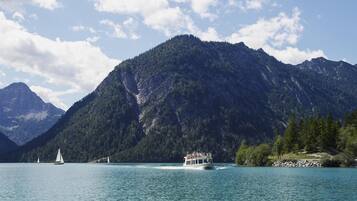 A boat on a lake with mountains in the background.