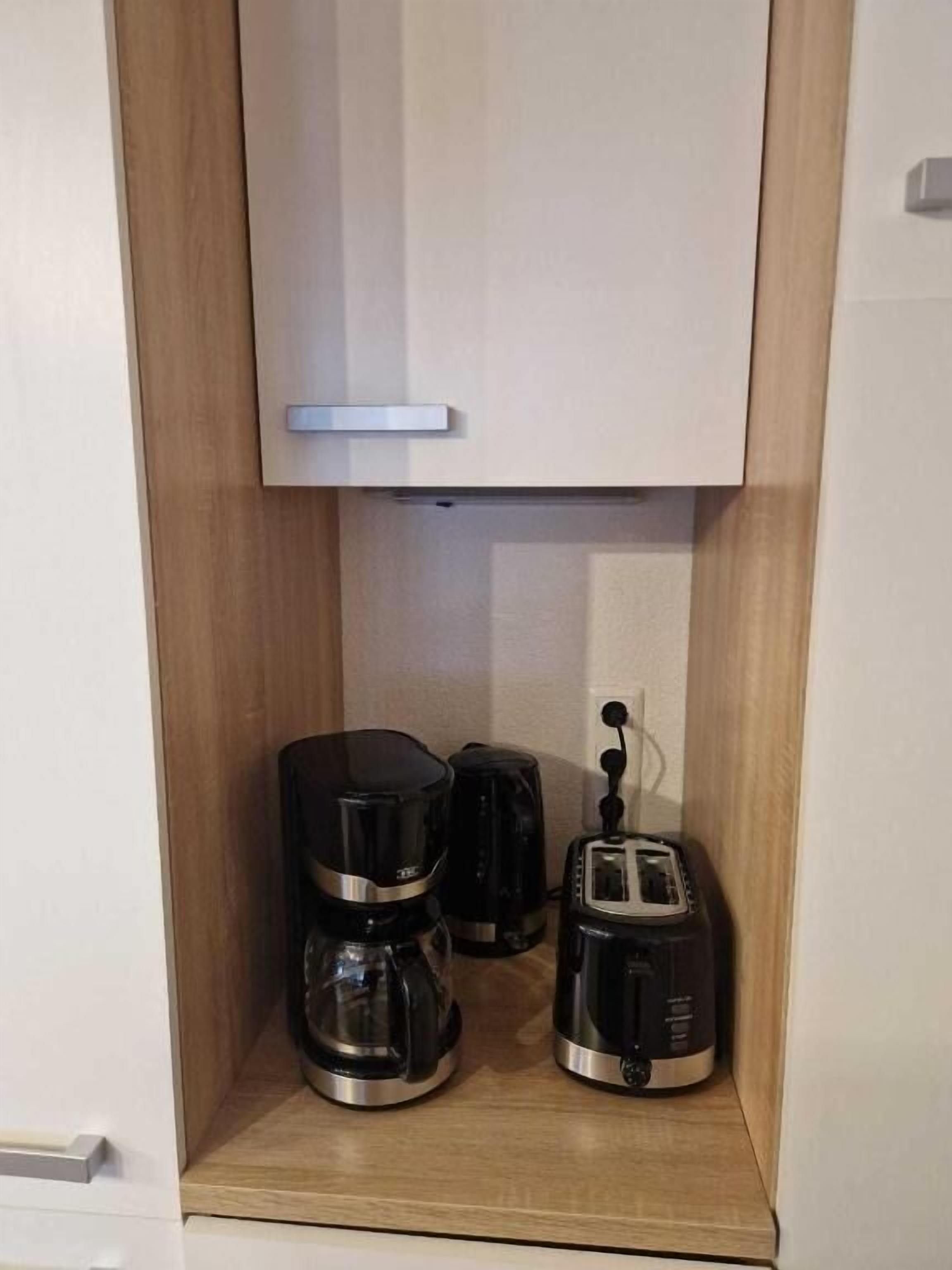 A kitchen with a built-in coffee maker and toaster.