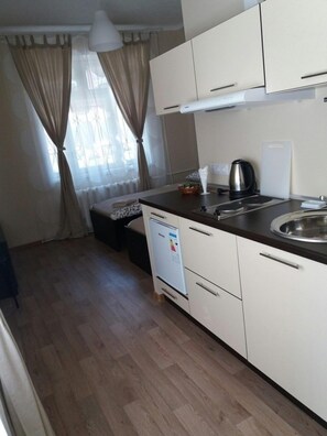 Comfort Twin kamer | Privékitchenette | Een koelkast, een kookplaat, een waterkoker, kookgerei, borden en bestek