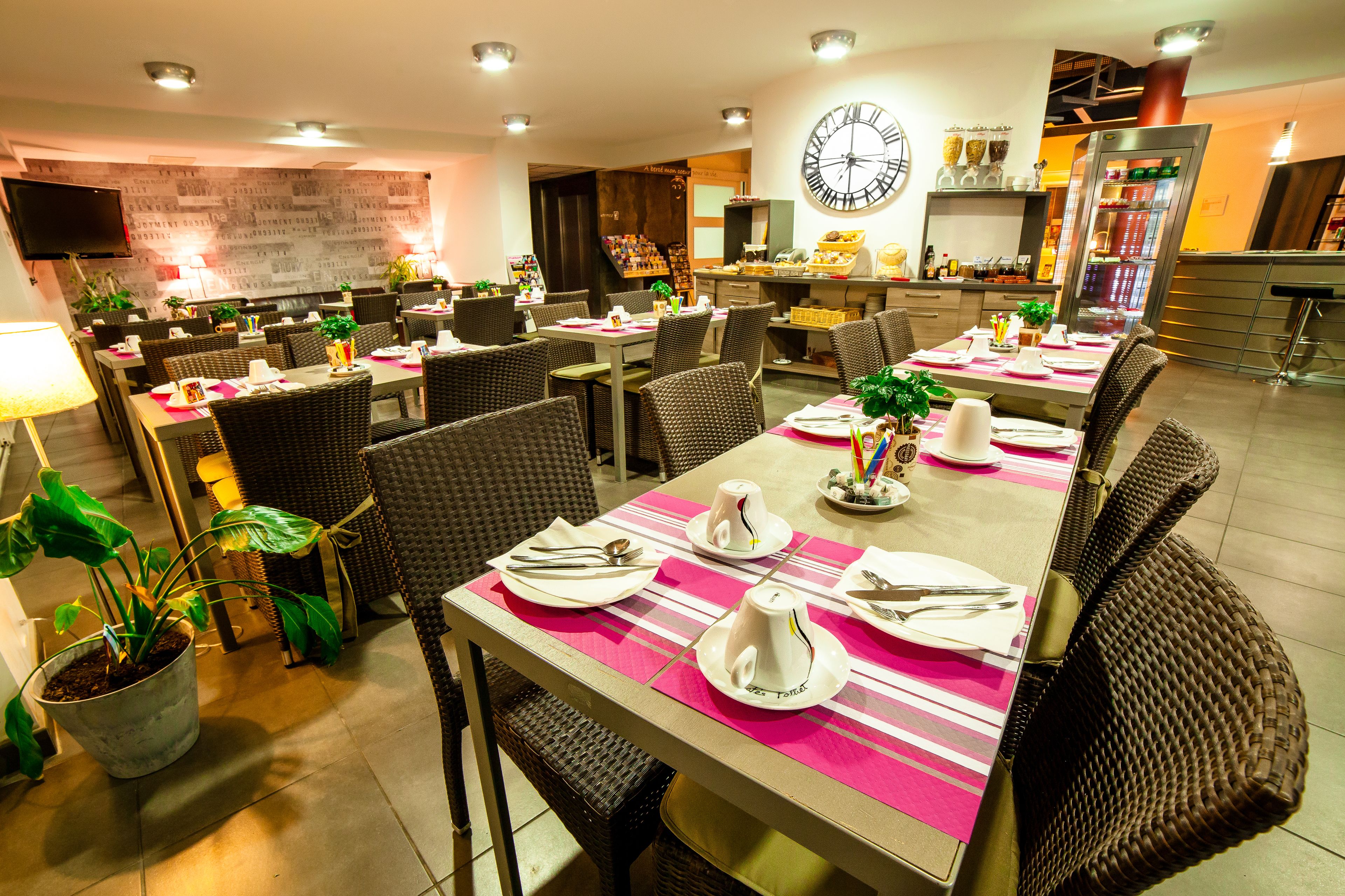 A restaurant with multiple dining tables, each set with plates, cutlery, and napkins.