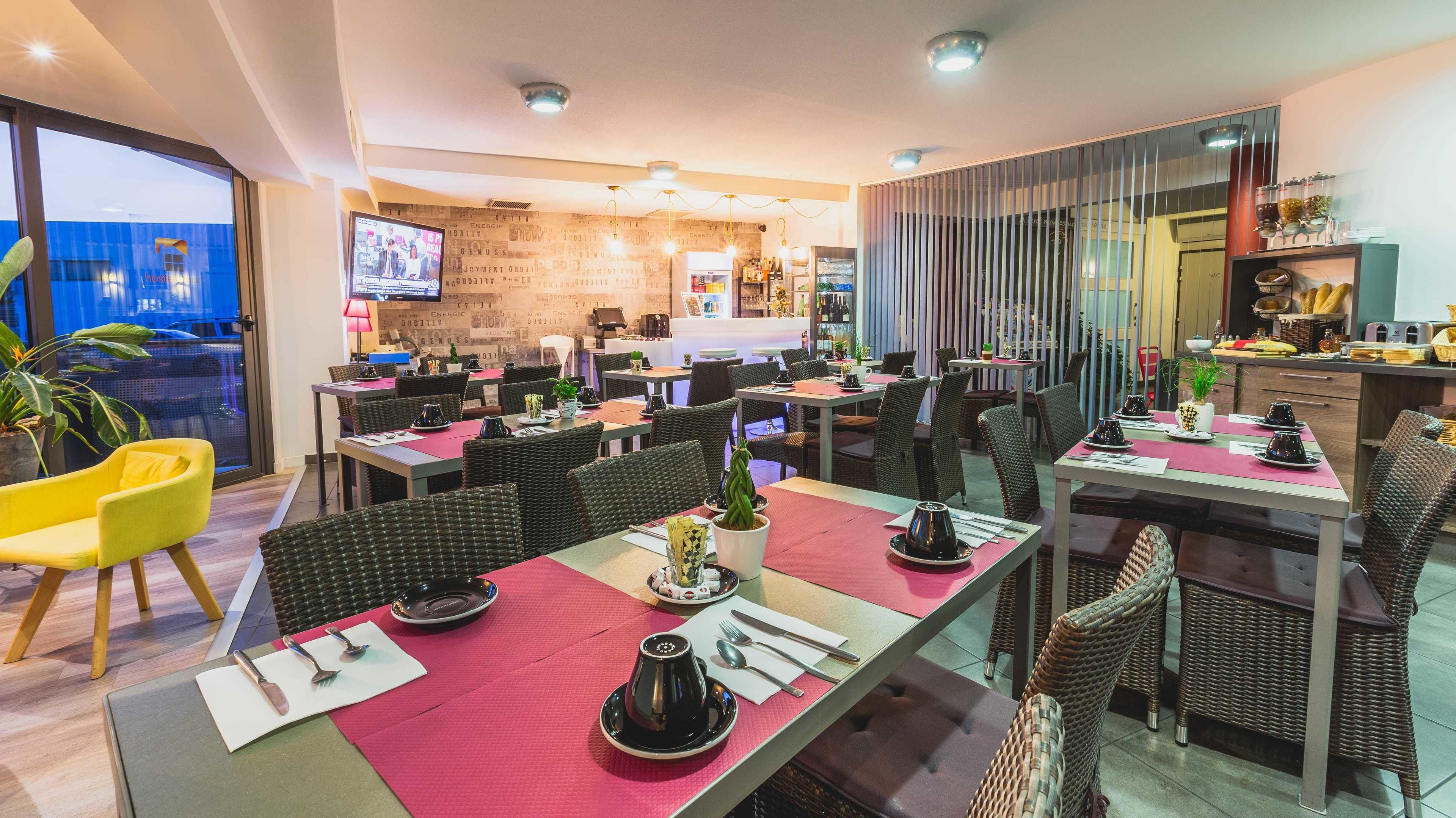 Een modern restaurant met meerdere eettafels, rieten stoelen en een bar.