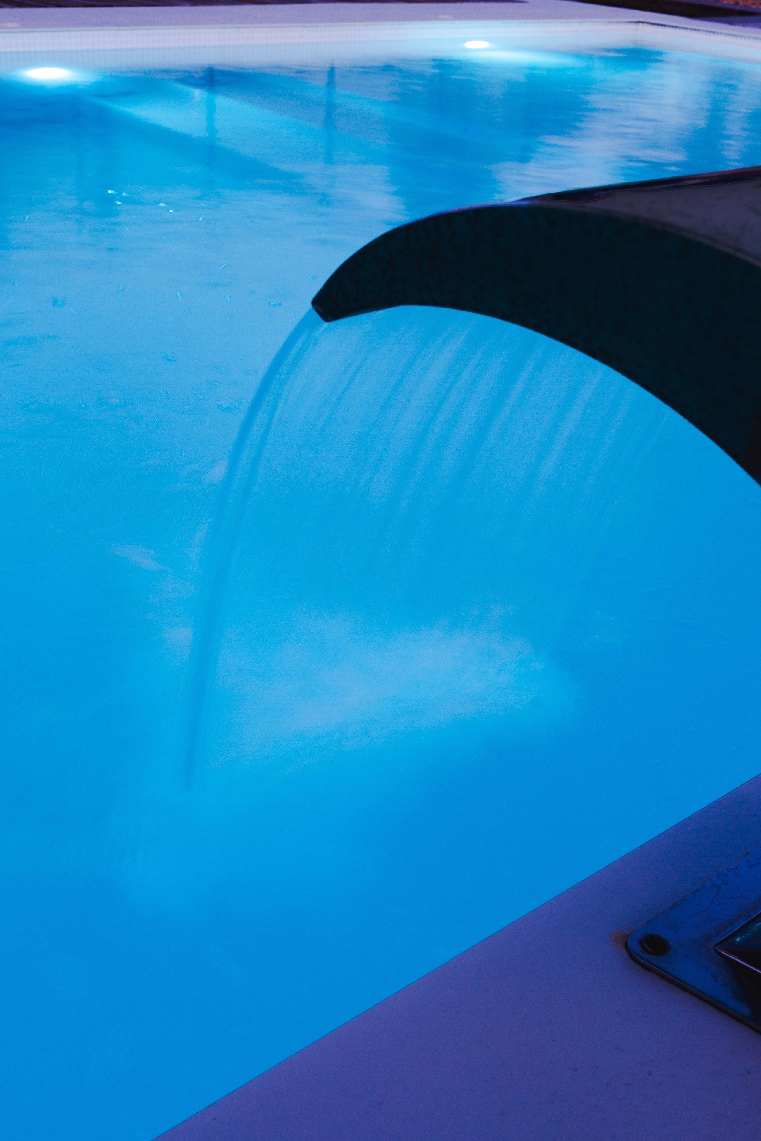 A pool with a clear blue water feature.
