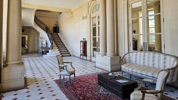 A grand lobby with a marble floor, a staircase, a sofa, and a coffee table. - Chateau de Craon (Craon)