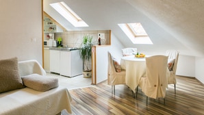 Un appartement moderne de style « loft », comprenant un coin repas, une cuisine et un espace salon confortable.