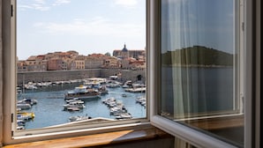 Une vue d’un port avec des bateaux et des bâtiments, dont une imposante structure en forme de dôme.