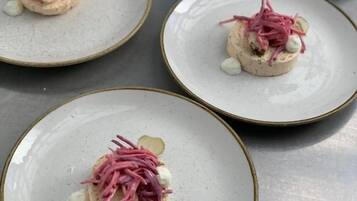 A tray with four plates of food, each with a central mound and garnished with pink and white elements.