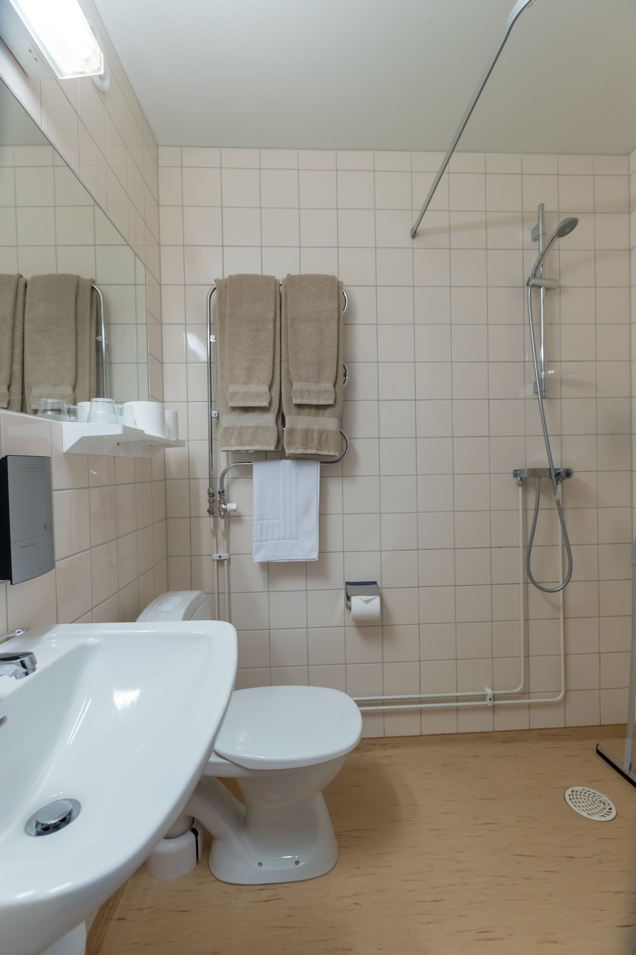 A bathroom with a sink, toilet, and shower.