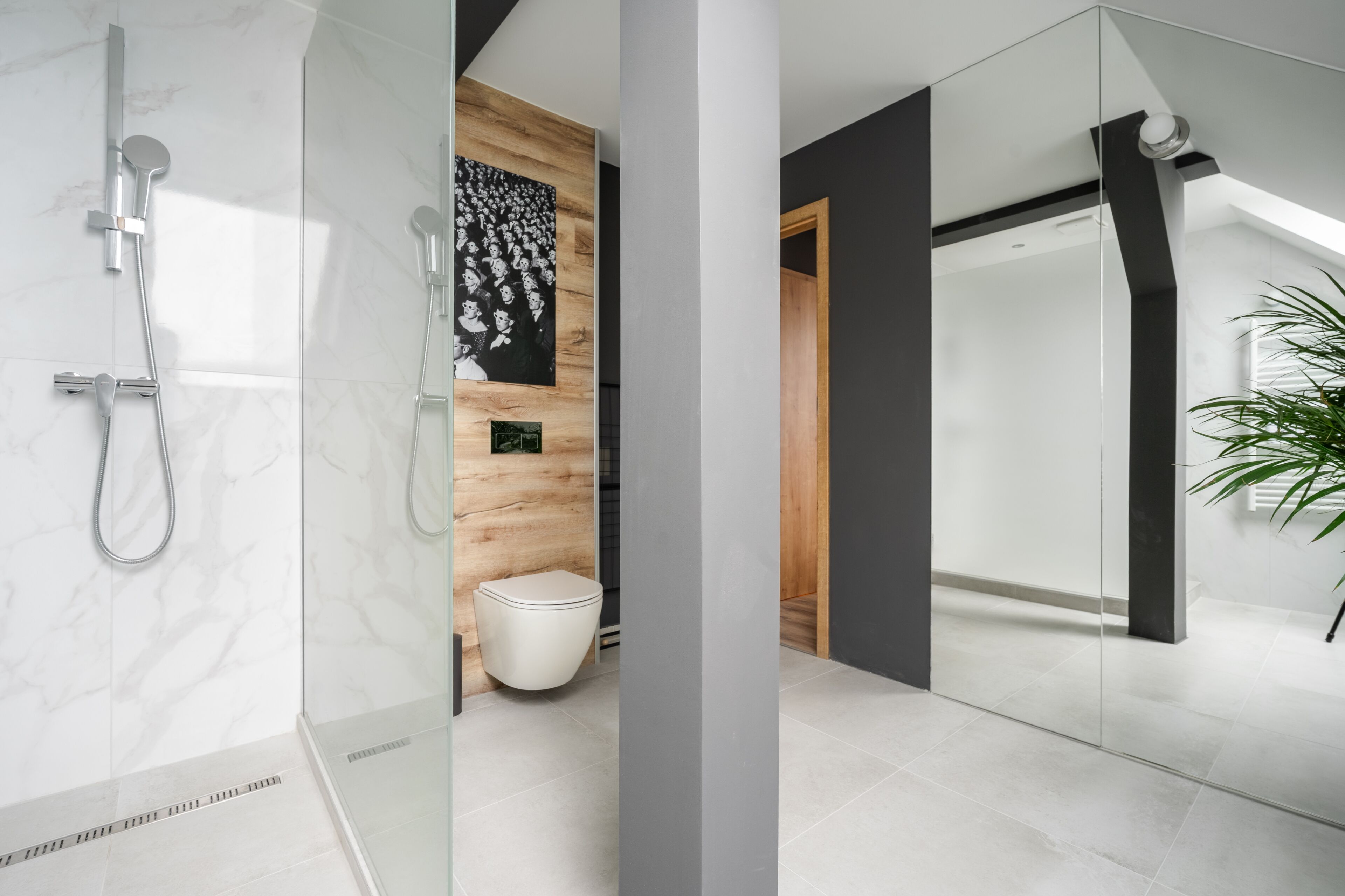 A modern bathroom with a glass shower enclosure, a wooden vanity, and a white toilet.