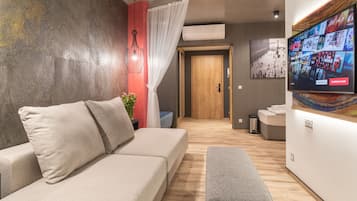 Deluxe family room with balcony on groundfloor | Living area | 75-cm flat-screen TV with satellite channels, TV