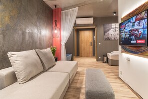 Deluxe family room with balcony on groundfloor | Living area | 75-cm flat-screen TV with satellite channels, TV - Onyx Luxury (Sarvar)