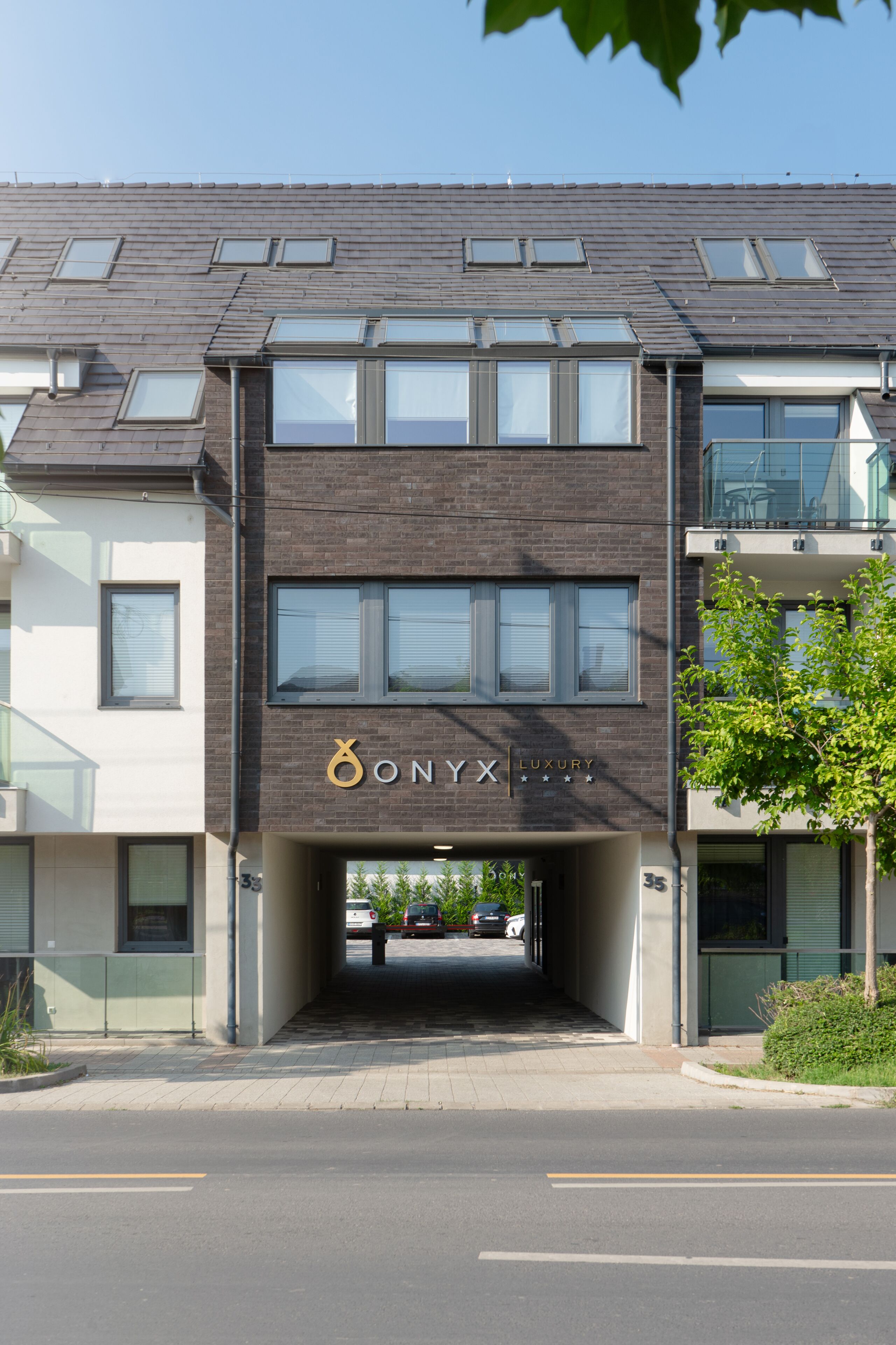 A modern building with a sign reading "ONYX LUXURY" and a covered entrance.