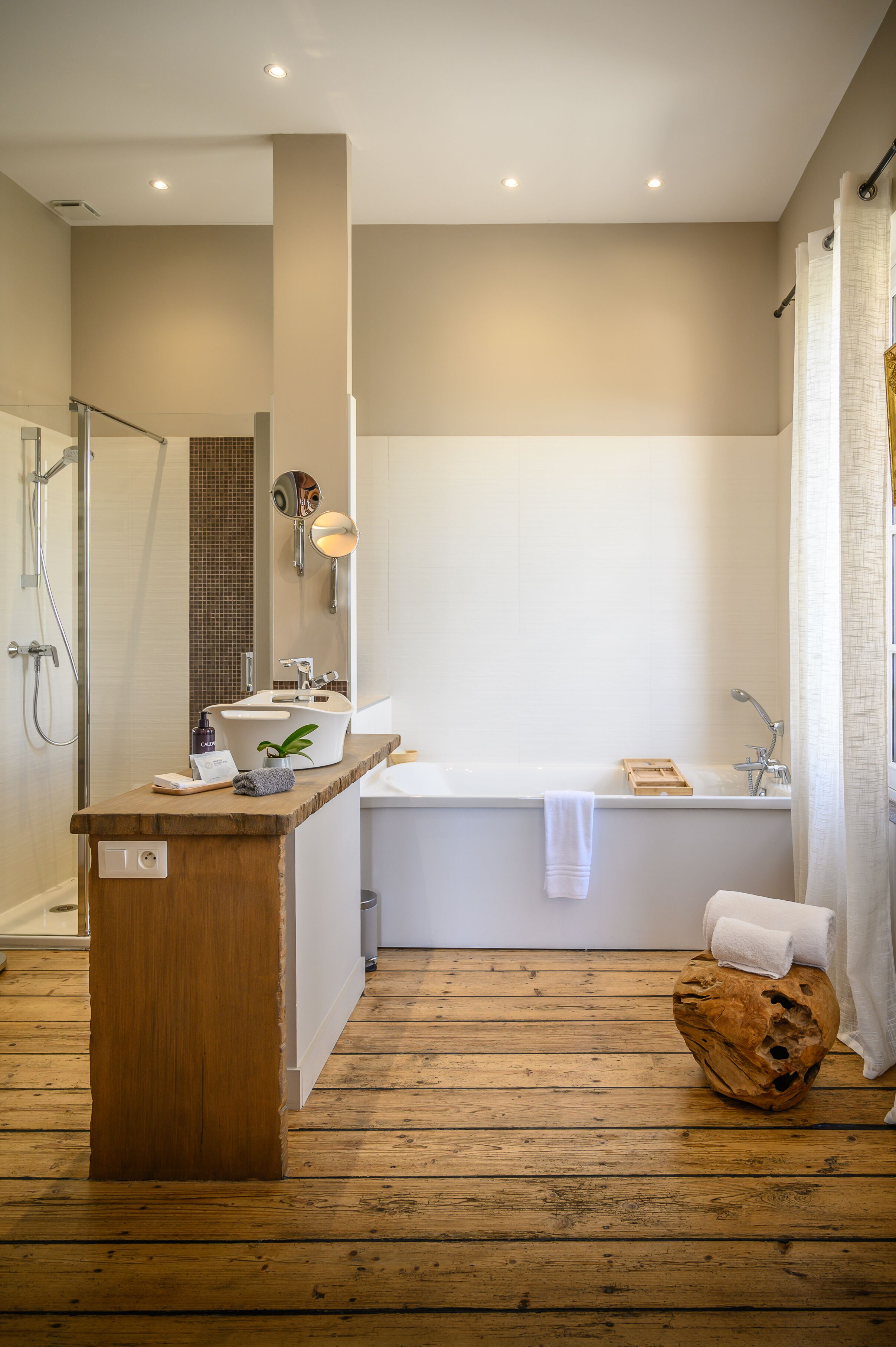 Ein modernes Badezimmer mit einem Holzbadezimmer-Möbel, einer Badewanne und einer Duschkabine.
