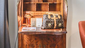 A wooden cabinet with a lamp, a Louis Vuitton bag, and a menu.