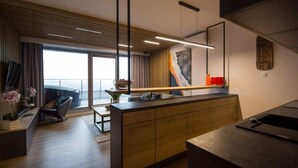 Una cocina moderna con una isla de madera, iluminación colgante y un amplio ventanal con vistas.