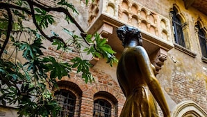 A statue in front of a building with arched windows and a brick facade. - DiMoras House (Verona)
