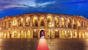 A historic building with a central archway and multiple arches along the sides. - DiMoras House (Verona)