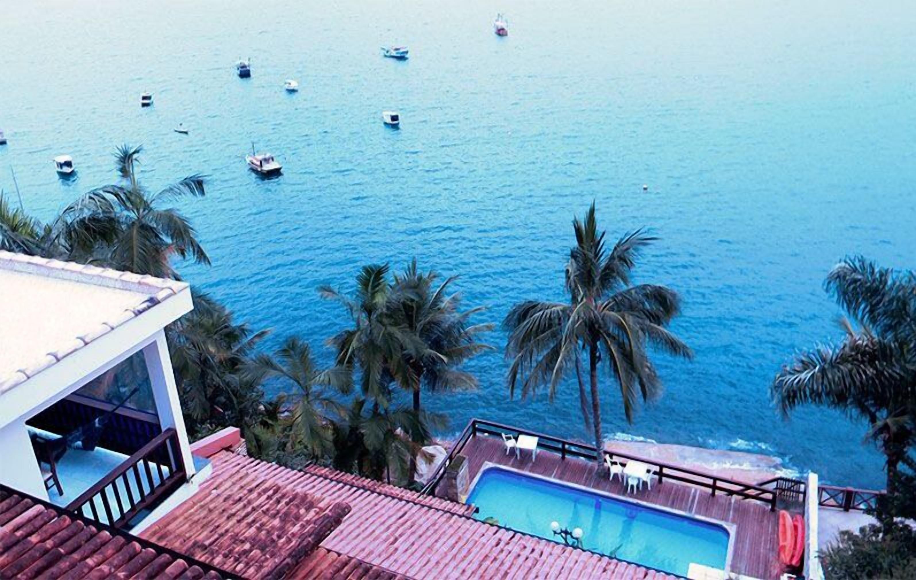 A pool area with a view of the sea and boats.