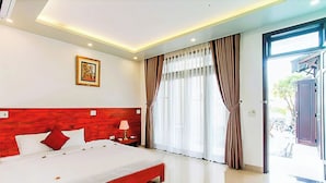 A modern hotel room with a large bed, a wooden headboard, a nightstand with a lamp, and a large window with curtains. - Gia Phat Homestay  (Da Nang)