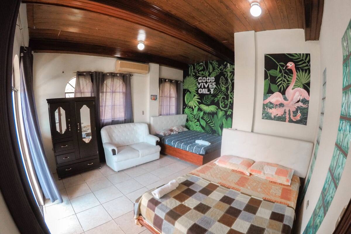 Une chambre avec un lit, un canapé, une armoire et une affiche accrochée au mur.